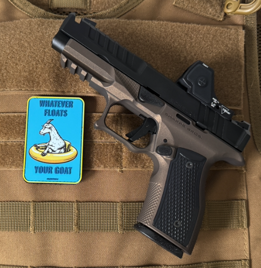 Pistol on a tactical pouch with a humorous patch featuring a goat.